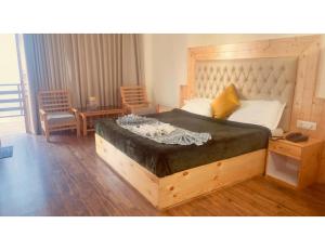 a bedroom with a large bed with a wooden headboard at Pine Shadow Retreat, Manali in Manāli