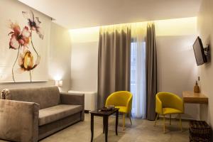 uma sala de estar com um sofá e cadeiras amarelas em Anemos Rooms & Apartments em Nafplio