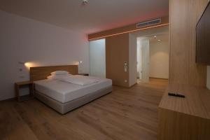 1 dormitorio con cama blanca y suelo de madera en Best Western Hotel Spinnerei Linz, en Linz