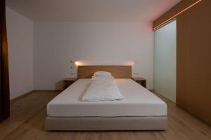 1 dormitorio con 1 cama blanca y suelo de madera en Best Western Hotel Spinnerei Linz, en Linz