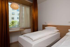 1 dormitorio con 2 camas y ventana en Best Western Hotel Spinnerei Linz, en Linz