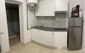 a kitchen with white cabinets and a stainless steel refrigerator at STUDIO ROSES PLAGE in Roses