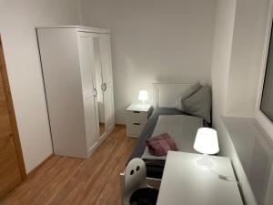 a small bedroom with a bed and a table at Lake & Town Apartments Klagenfurt in Klagenfurt