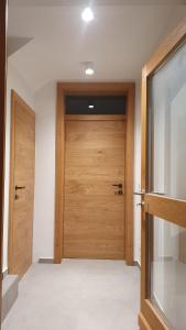 a hallway with a wooden door in a house at Lake & Town Apartments Klagenfurt in Klagenfurt