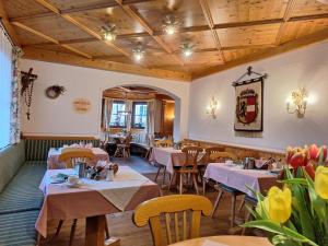 un restaurante con mesas, sillas y flores en Hotel Stegmühlhof, en Mauterndorf