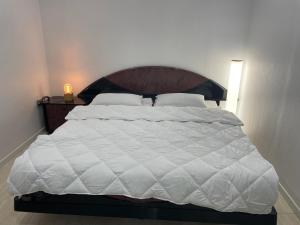 a large white bed with a wooden headboard in a bedroom at STUDIO ROSES PLAGE in Roses