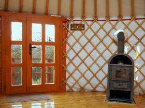 a wood stove in a room next to a door at Kadosa Jurta Apartman in Esztergom