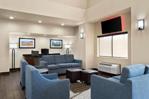 ein Wartezimmer mit Sofas, einem Schreibtisch und einem TV in der Unterkunft Comfort Suites University in Las Cruces