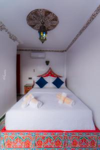 Un pat sau paturi într-o cameră la Hotel Chefchaouen