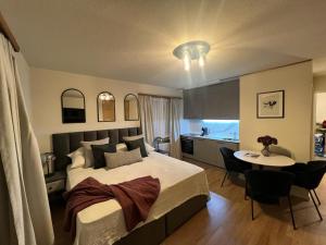 een slaapkamer met een bed en een tafel en een keuken bij Chalet Alberti Davos Platz in Davos