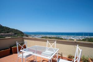 uma mesa e cadeiras numa varanda com vista em Miramare apartments em Punta Ala