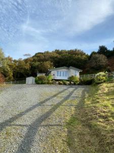 une maison avec une clôture et une allée en gravier dans l'établissement Roberts’ Cottage, à Westport