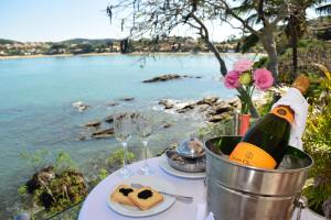 a table with a bottle of wine and some wine glasses at Hotel Ferradura Private in Búzios