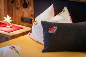 una camera da letto con un letto con cuscini sopra di Chalets Almdorf Haidenberg a Brunico