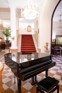 - un piano à queue dans le hall avec un escalier dans l'établissement Parkhotel 1901 Mannheim, à Mannheim