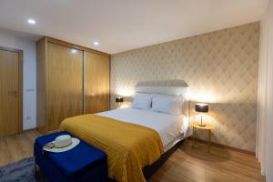 a bedroom with a large bed with a yellow bedspread and a yellow blanket at Live in Aveiro in Aveiro