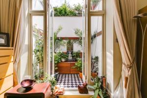 une chambre avec une porte donnant sur une cour ornée de plantes dans l'établissement Georgiana's Guesthouse, à Londres