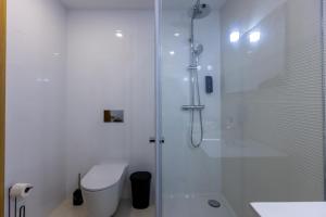 a white bathroom with a shower and a toilet at Live in Aveiro in Aveiro