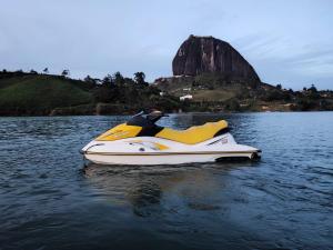 um jet ski amarelo e branco sentado na água em HOTEL Mirador Cielo Blue em El Peñol