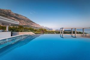 una piscina con acqua blu e una montagna sullo sfondo di Boutique Hotel Mirjam a Makarska