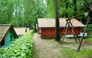 um edifício vermelho com uma escada ao lado de uma casa em Waldidylle - Bungalows an der Talsperre Kriebstein em Kriebstein