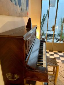 un piano sentado junto a una habitación con ventana en Riad Dar-tus, en Tánger