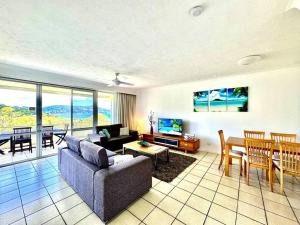 ein Wohnzimmer mit einem Sofa und einem Esszimmer in der Unterkunft Poinciana 105 in Hamilton Island