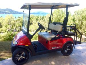 einen kleinen roten Golfwagen mit Baldachin in der Unterkunft Poinciana 106 in Hamilton Island