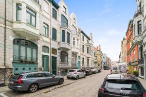 eine Stadtstraße mit auf der Straße geparkt in der Unterkunft Karaktervolle en ruime woning aan zee voor 10p in Ostende