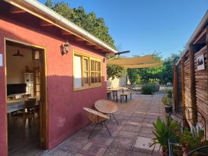 a patio with a table and chairs and an umbrella at Scorpius Hostel in Vicuña