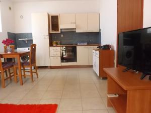 cocina con TV y mesa de comedor en Latmo Apartment Zadar, en Zadar