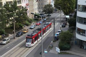 um ônibus vermelho e branco dirigindo por uma rua com carros em Hotel Alt-Erfurt em Erfurt