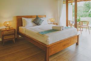 ein Schlafzimmer mit einem großen Bett mit einem Tisch und Stühlen in der Unterkunft Uma Raos Cottage in Ubud