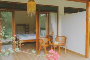 Schlafzimmer mit einem Bett, einem Tisch und Stühlen in der Unterkunft Uma Raos Cottage in Ubud