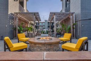 メテリーにあるCountry Inn & Suites by Radisson, Metairie New Orleans , LAのパティオ(黄色い椅子、ファイヤーピット付)