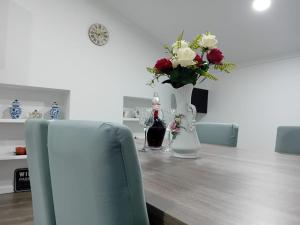 a table with a vase of flowers and a bottle of wine at Apartment in Semeador in Portalegre