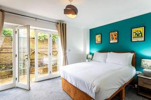 a bedroom with a bed and a green wall at Light and airy upside down house in Hackney in London