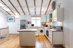 a large kitchen with a washer and dryer at Light and airy upside down house in Hackney in London