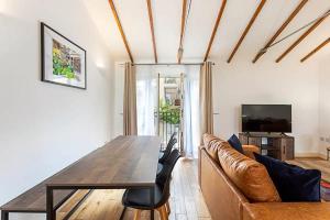 a living room with a wooden table and a couch at Light and airy upside down house in Hackney in London