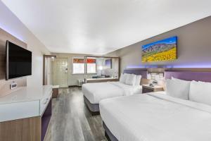 エルパソにあるBest Western Sunland Parkのベッド2台、薄型テレビが備わるホテルルームです。