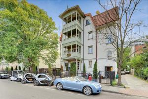 eine Gruppe von Autos, die vor einem Haus geparkt sind in der Unterkunft Mała Anglia Deluxe Rooms & SPA in Sopot