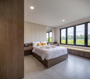 - une chambre avec un grand lit et de grandes fenêtres dans l'établissement Verdant Bali Sekar Sari, à Denpasar