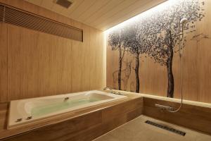 ein Badezimmer mit einer Badewanne und einem Wandgemälde in der Unterkunft HOTEL FOURSEASONS KITAKAMI Adult only in Kitakami