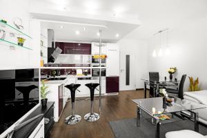 BNB New Beautiful Apartment in the Center of Ostrava with option Garage Parking في Moravská Ostrava: مطبخ وغرفة معيشة بجدران بيضاء