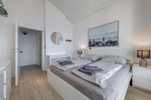 um quarto branco com 2 camas e um espelho em Luxury apt w pool 3 balconies terrace & sea view em Omiš