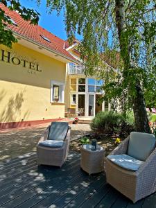 two chairs and a table in front of a hotel at Hotel Penta Lux in Tata