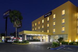 un hôtel avec des voitures garées dans un parking dans l'établissement City Express by Marriott Nuevo Laredo, à Nuevo Laredo