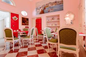 une salle à manger avec des murs roses et des chaises vertes dans l'établissement The Crown Palace - Gallipoli, à Gallipoli