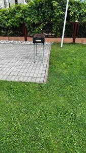 un objet noir est assis sur l'herbe dans l'établissement Japandi apartamentai, à Kaunas