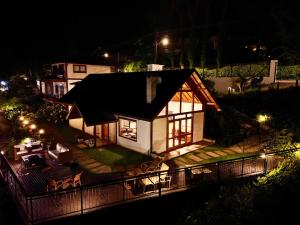 una piccola casa con tetto nero di notte di Chalés Mirante Monte Verde a Monte Verde